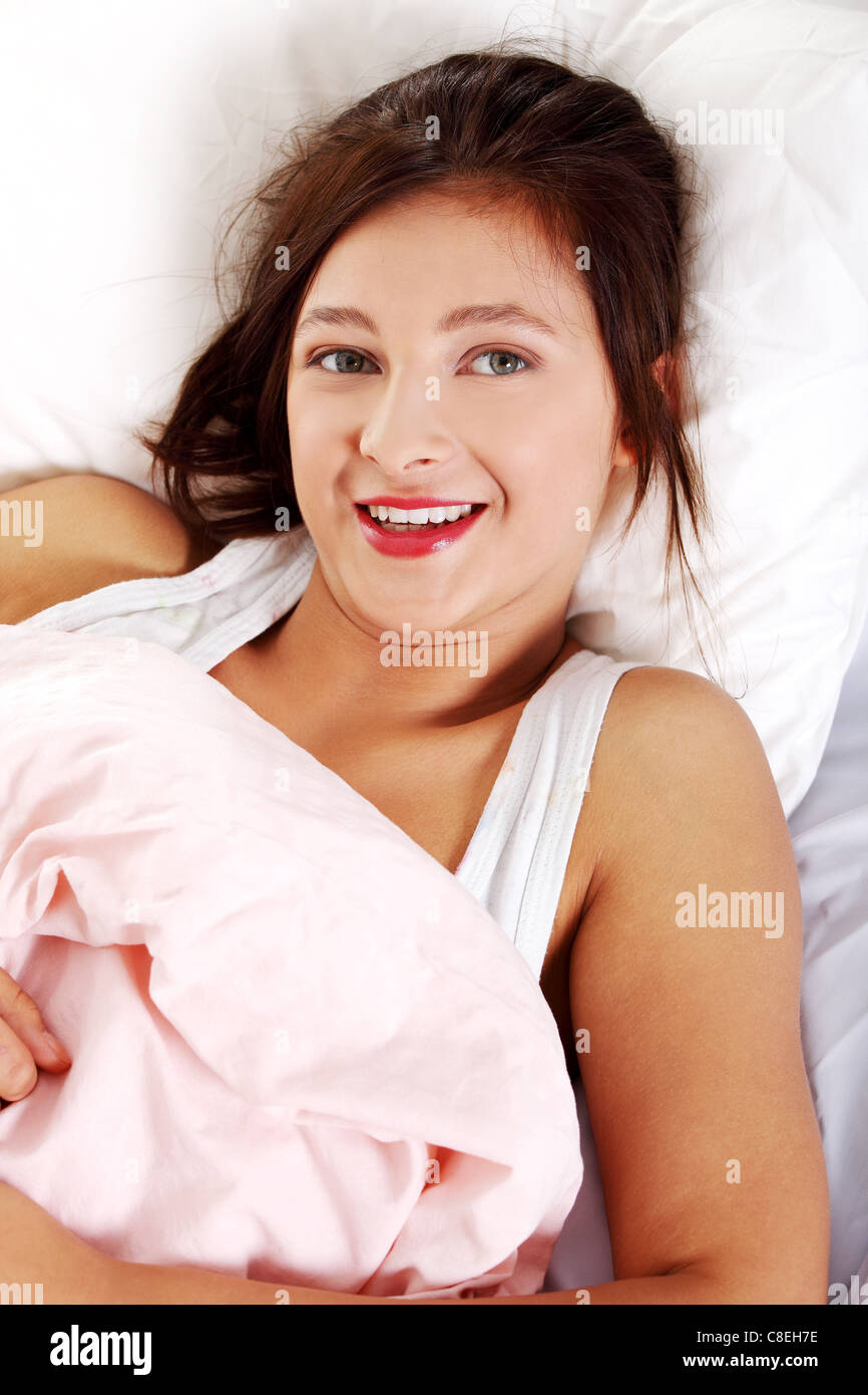 Teen smiling girl lying in bed ang smiling Stock Photo Alamy