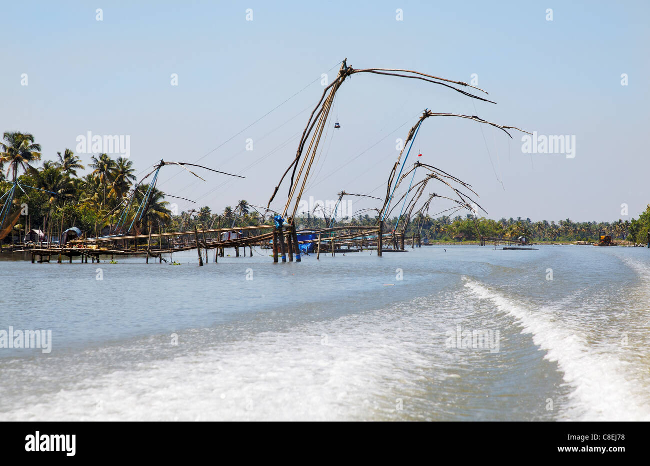 Landscape Fishing Kerala Backwaters India Lakes Texture patterns, passing speedboat  wake and sea spray, blue sky horizontal Stock Photo