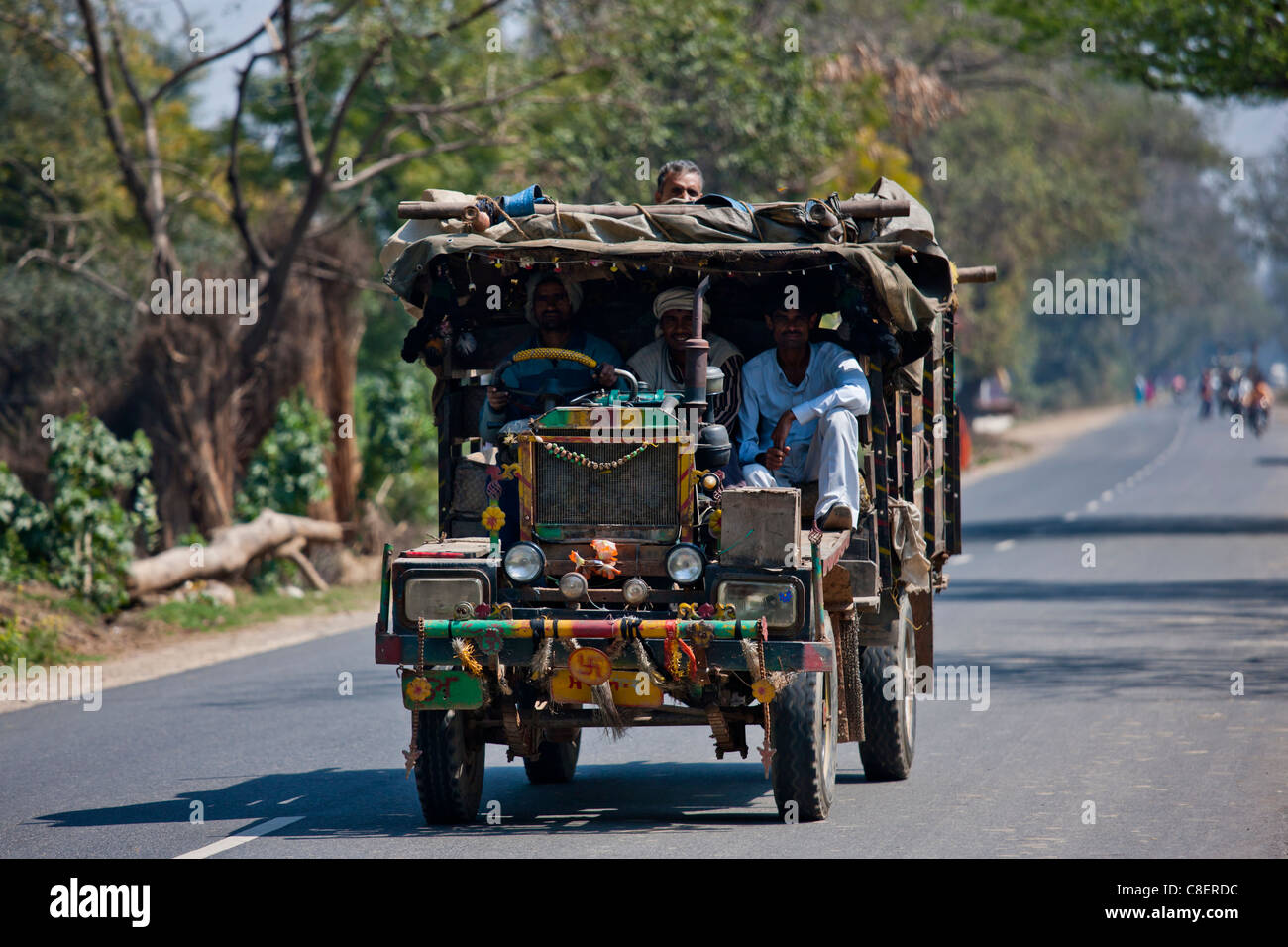 Indian workers travel in brightly coloured truck in Agra, Uttar Pradesh, India Stock Photo