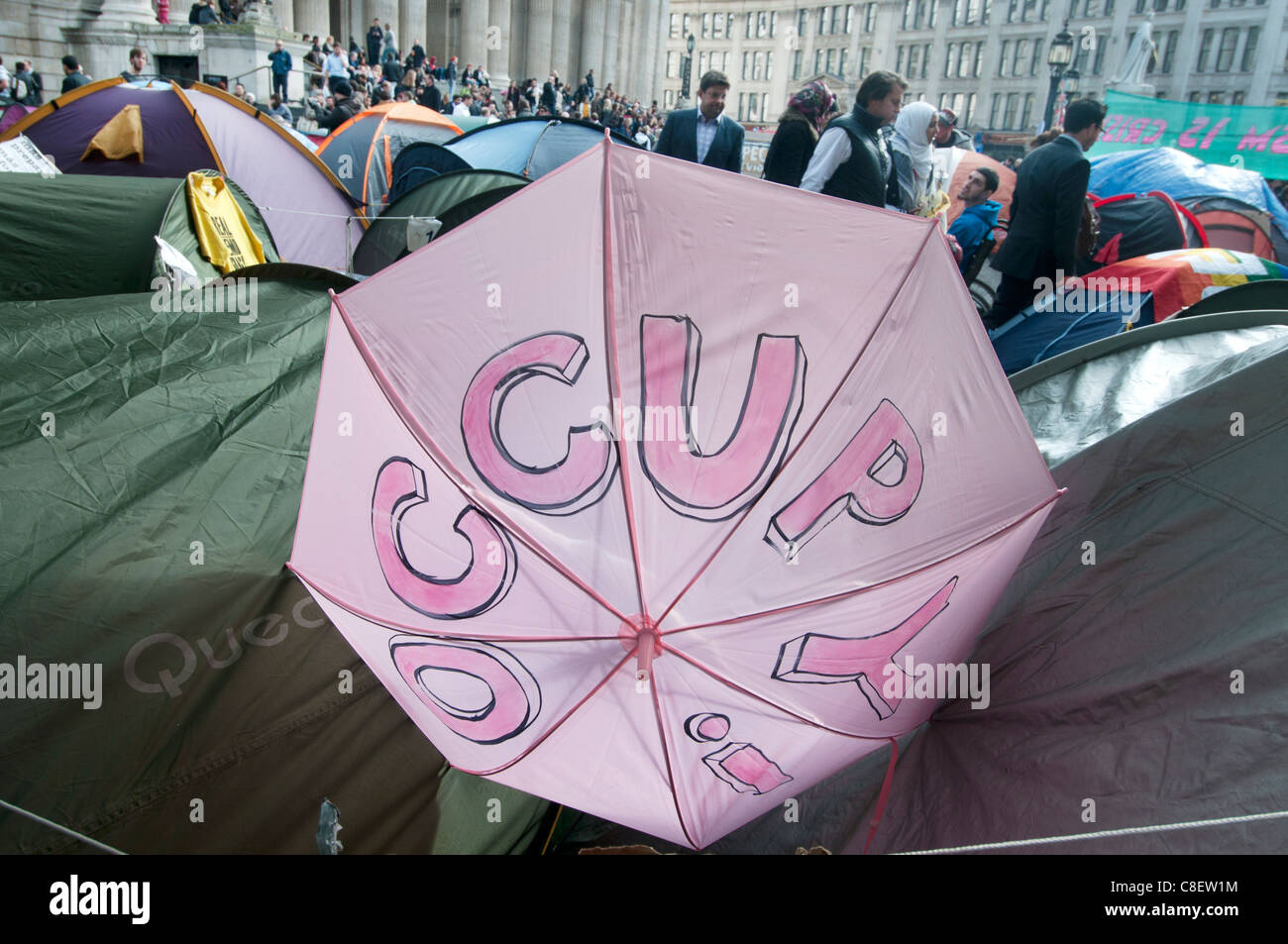 Occupy the London Stock Exchange camp in front of St Paul's to protest at economic situation.Umbrella saying Occupy Stock Photo