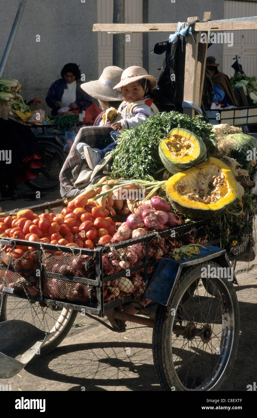 Juliaca, Peru. Rural Indians with their produce - tomatoes, onions, carrots, potatoes, pumpkins at market. Stock Photo