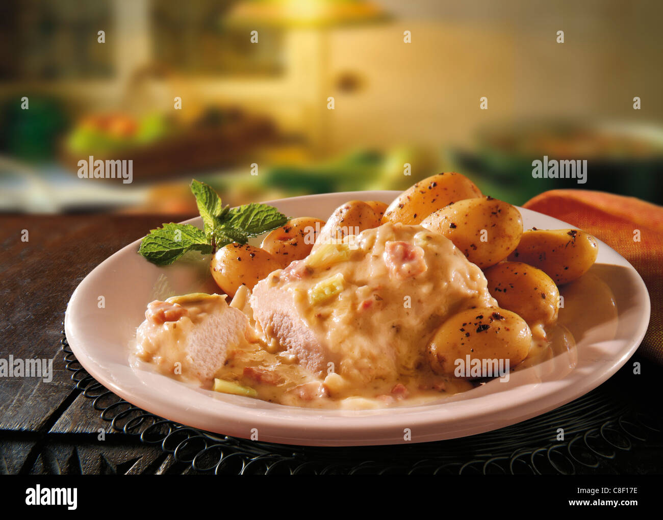 Traditional British  Wiltshire Chicken casserole served with mashed potatoes on a plate in a rustic kitchen Stock Photo
