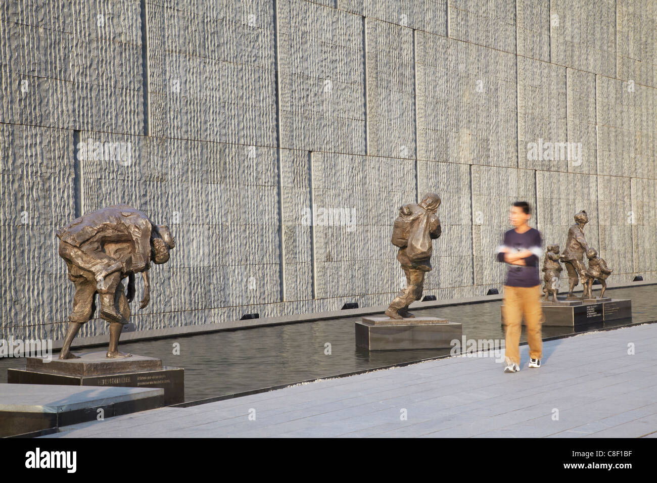 Man walking past statues at Memorial for the Nanjing Massacre, Nanjing, Jiangsu, China Stock Photo
