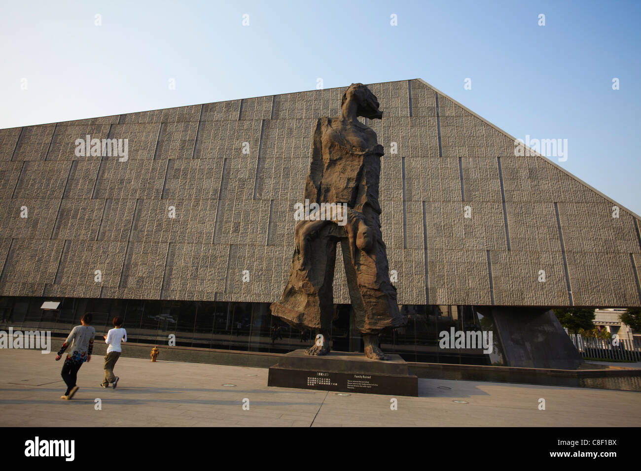 People walking past statues at Memorial for the Nanjing Massacre, Nanjing, Jiangsu, China Stock Photo