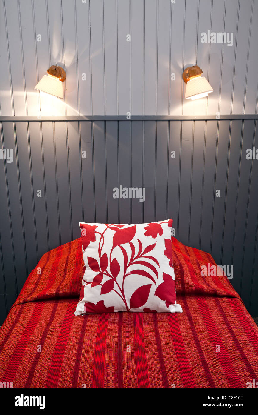 A bed in a wood-panelled room (Scandinavian style). Lit dans une chambre lambrissée (Style Scandinave). Stock Photo