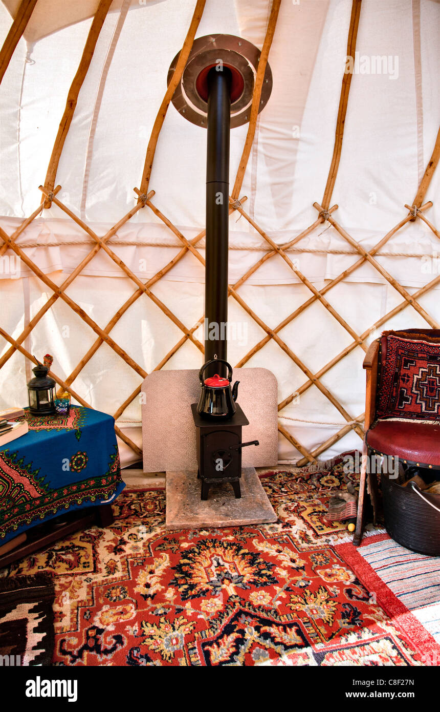Interior of small 10' homemade yurt with stove and rugs Stock Photo