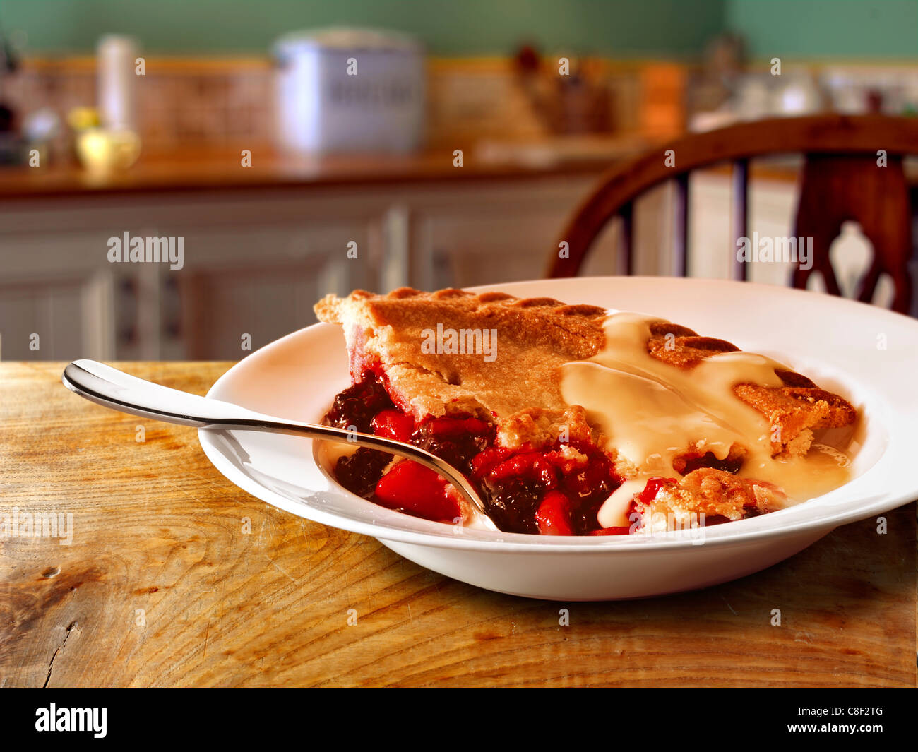 Traditional British fruit pie and custard pudding served hot in a bowl on a table in a