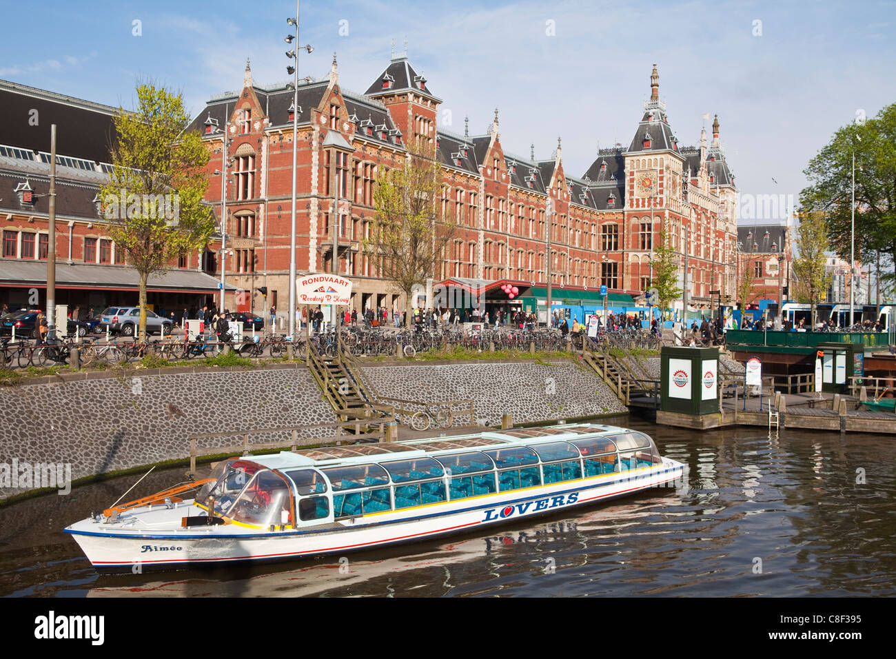 Canal tour boat outside Centraal Station, the central train station, Amsterdam, Netherlands Stock Photo