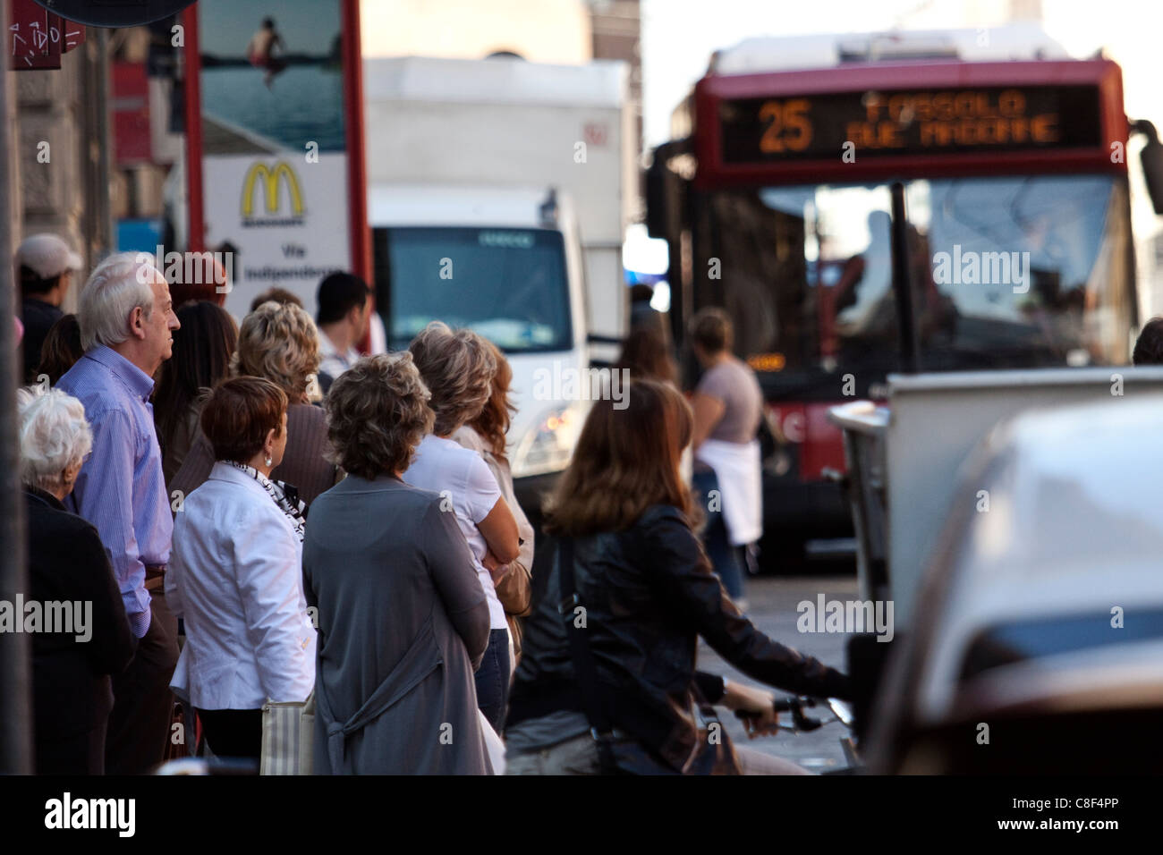 People queue at the bus stop in their routine life. Stock Photo