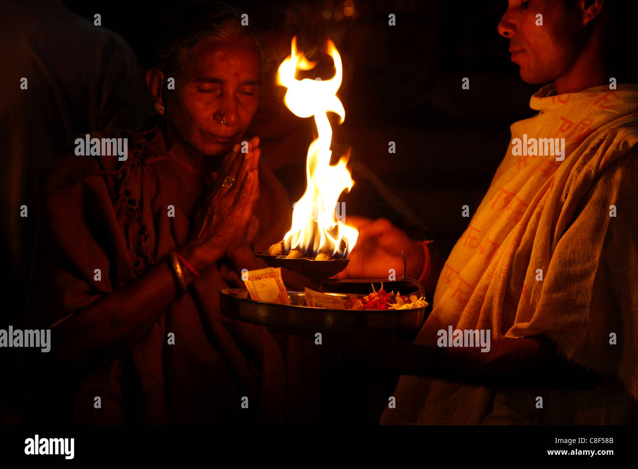 Priest and devotee performing aarti, Haridwar, Uttarakhand, India Stock Photo
