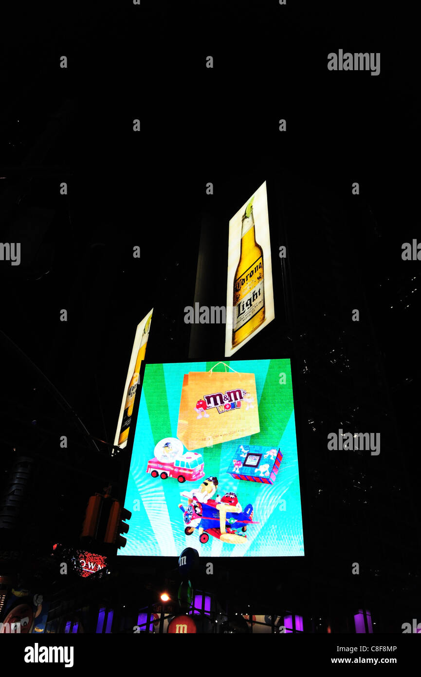 Night shot neon screen with kiddies images advertising M&M sweets, M&M World candy store, 7th Avenue, Times Square, New York Stock Photo