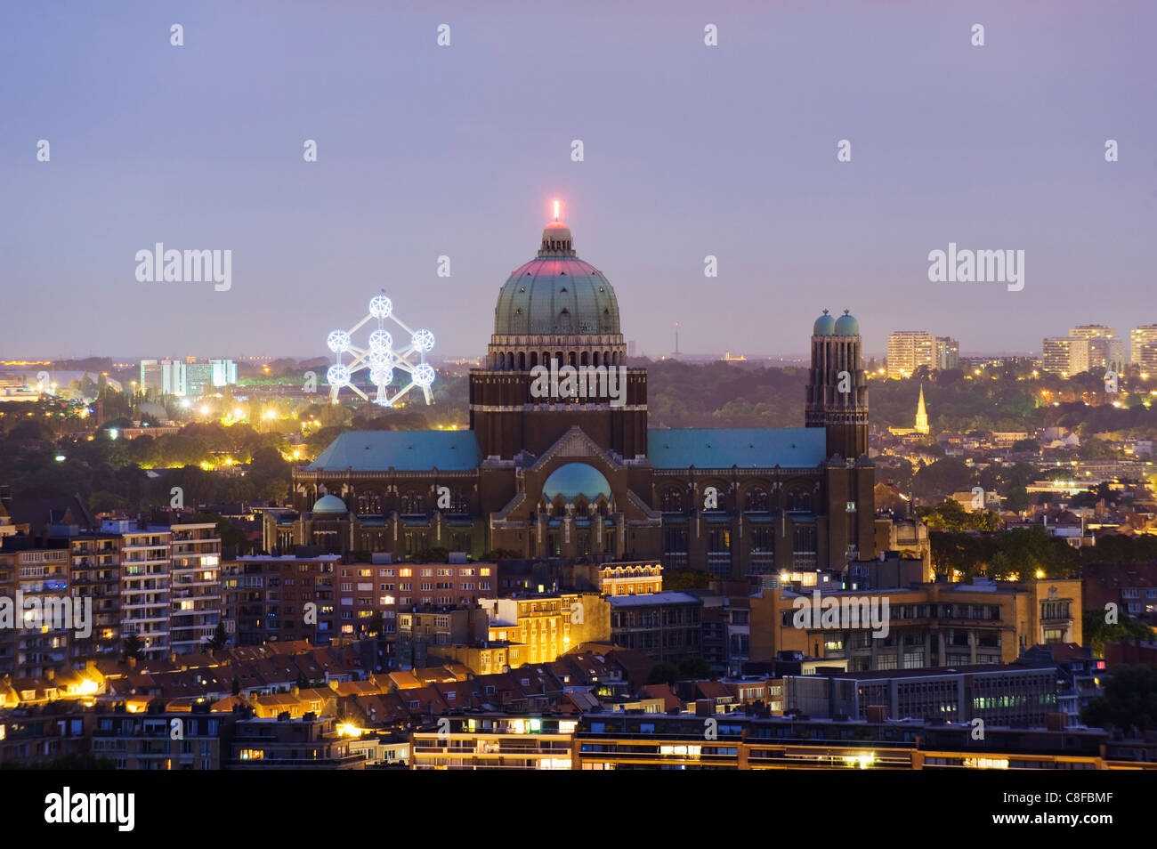National Catholic Church and Atomium, panoramic view of the city illuminated at night, Brussels, Belgium Stock Photo
