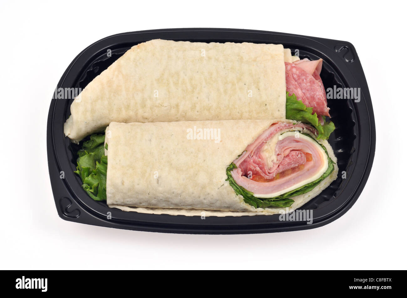 Italian deli meat wrap or roll-up sandwich with cheese lettuce & tomatoin black to go container on white background, cut out. USA Stock Photo