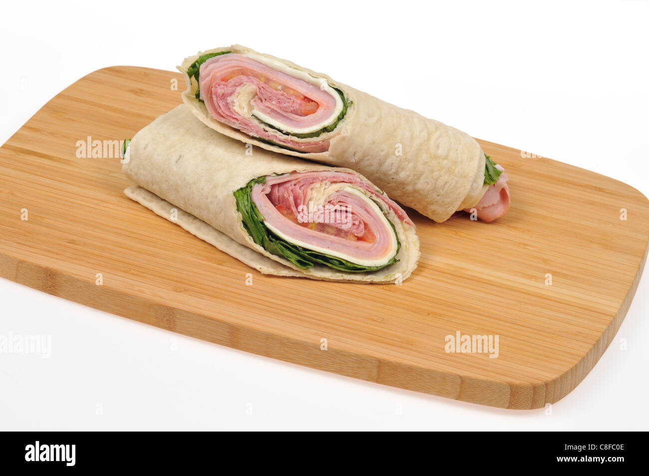 Italian wrap sandwich on wood cutting board on white background, USA Stock Photo