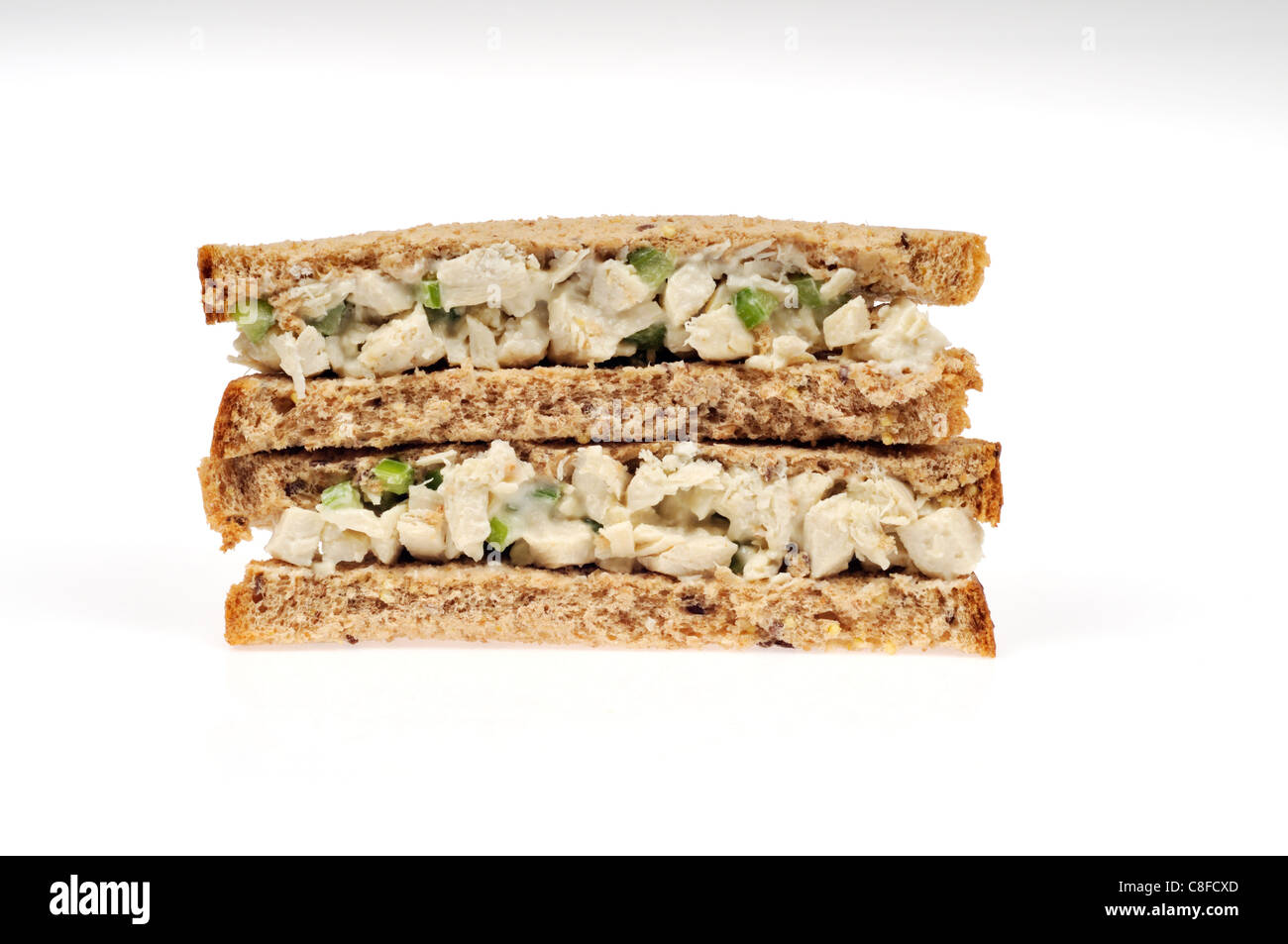 Chicken salad sandwich with celery & mayo on wholemeal brown bread on white background cutout. Stock Photo