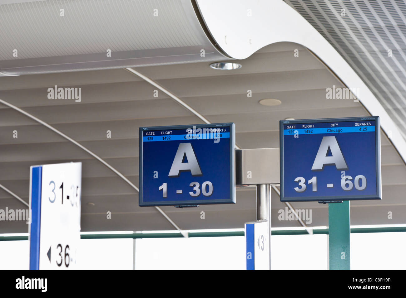 Signs guide passengers to gates in Orlando International Airport in Orlando, Florida Stock Photo
