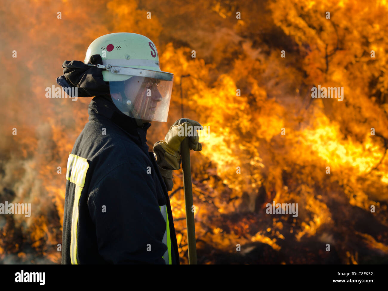 Fireman at bonfire Stock Photo