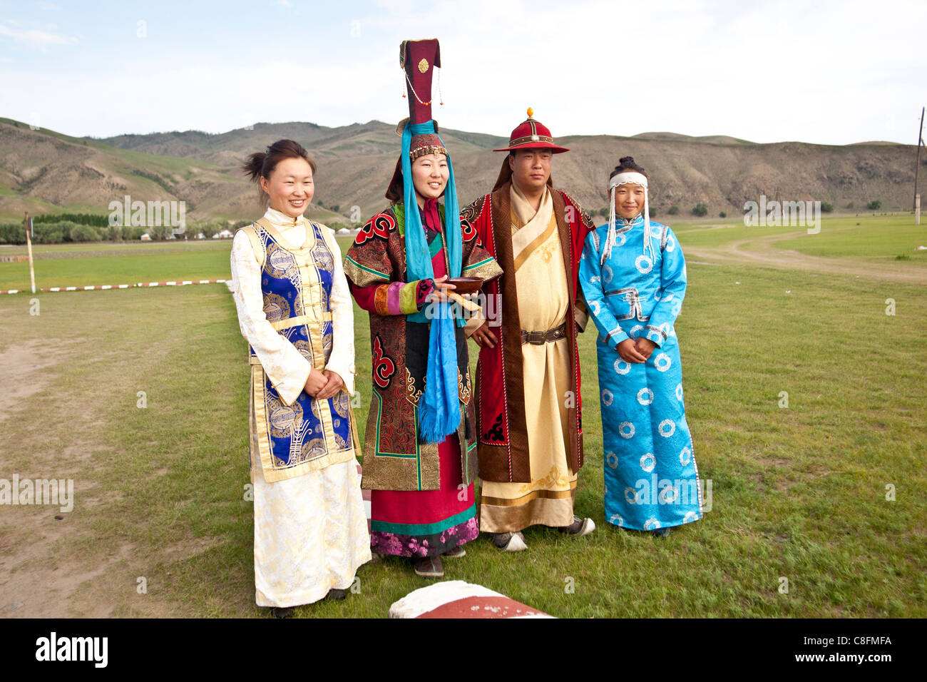 Nomad Mongolians in traditional dress preparing for a welcoming ceremony with milk. Stock Photo