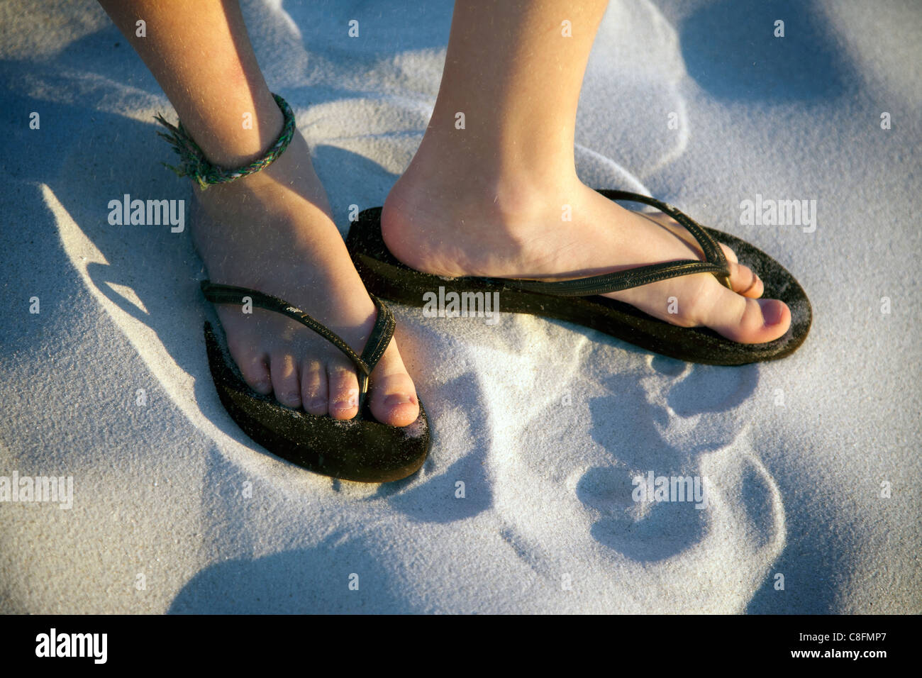 Child wearing sandals on the beach Stock Photo