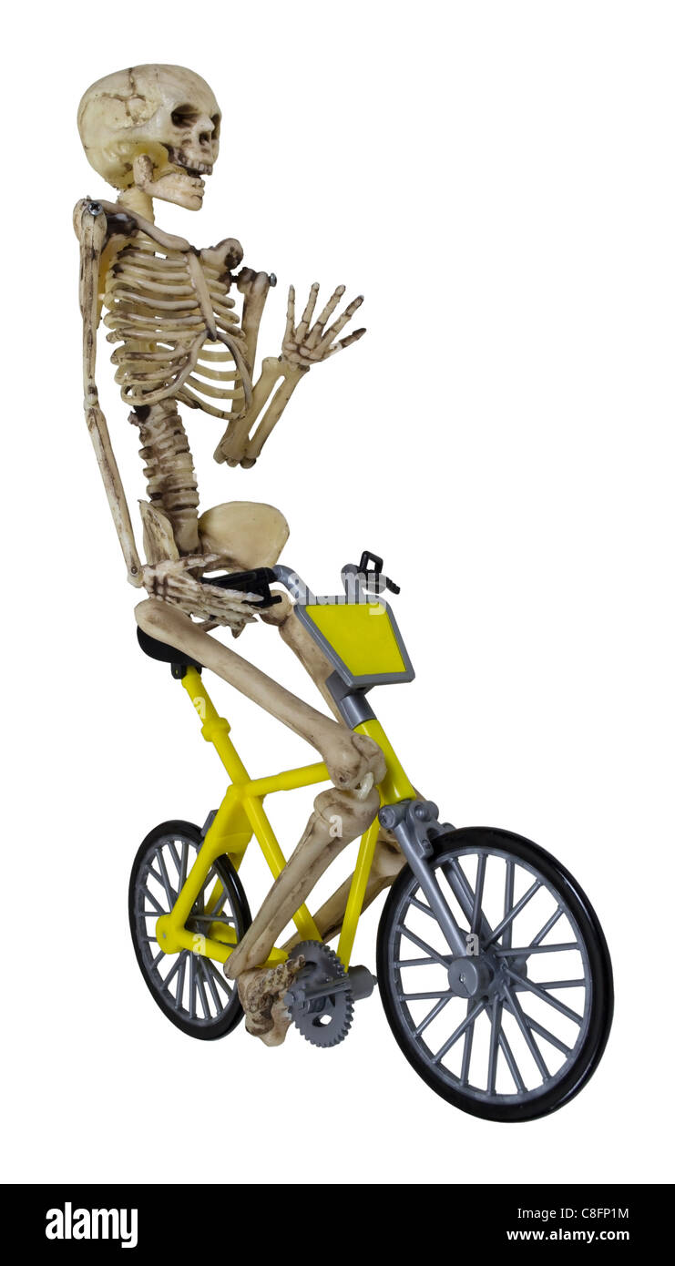 Skeleton riding a yellow bicycle with his hand raised - path included Stock Photo