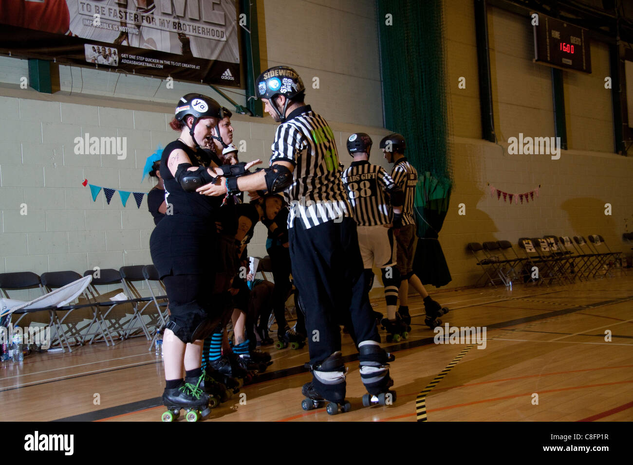 Referees check a visiting team's safety equipment before a roller derby
