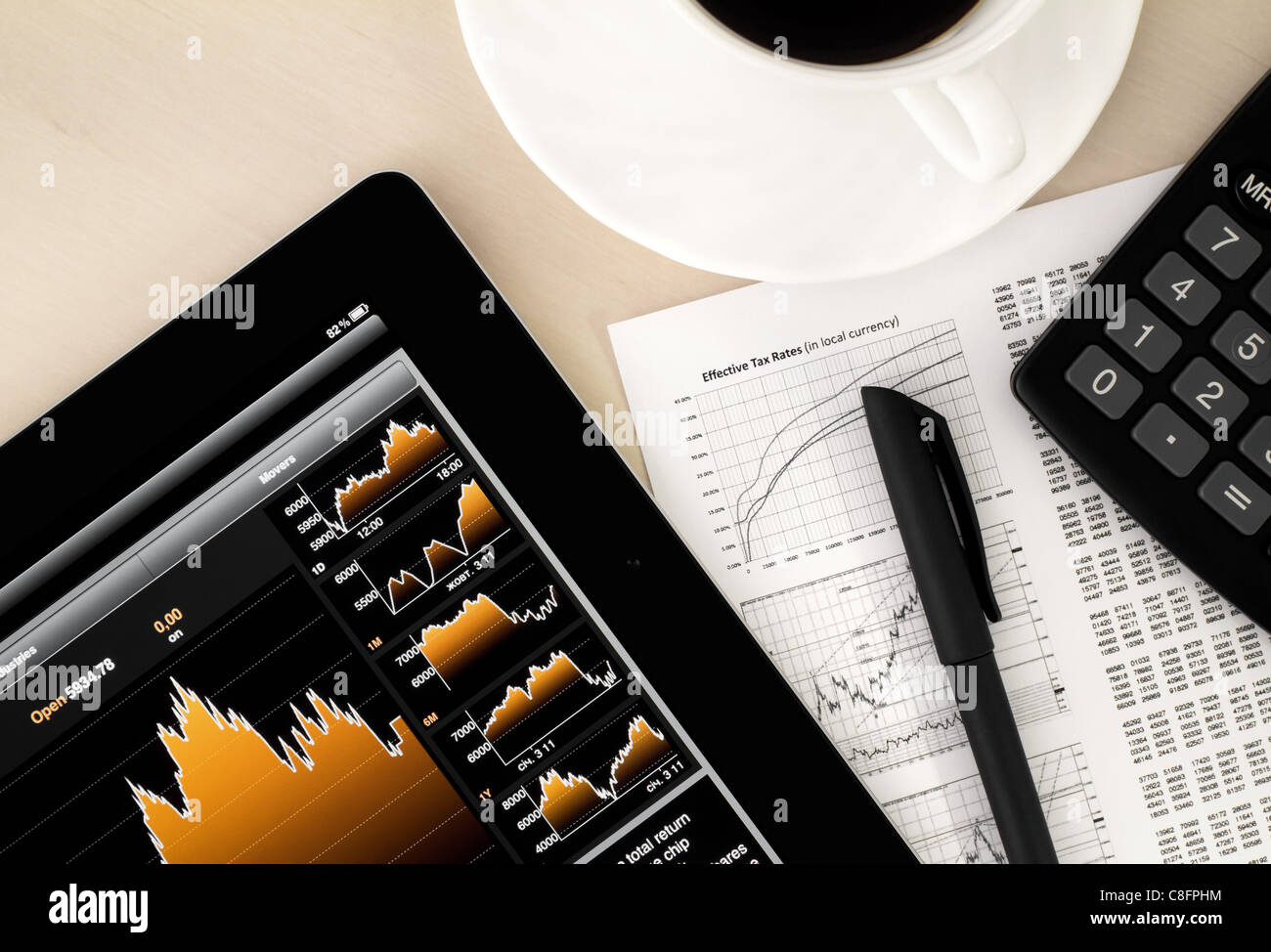 Desktop in stock exchange office with a tablet pc showing stock market chart. Stock Photo