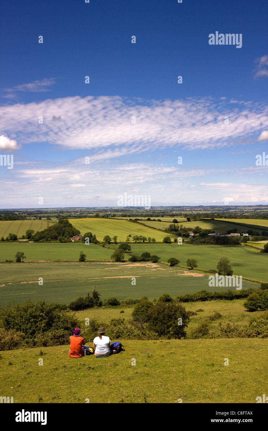 Couple sitting having a picnic near the summit of Burrough Hill with far reaching views over rural Leicestershire, England, UK Stock Photo