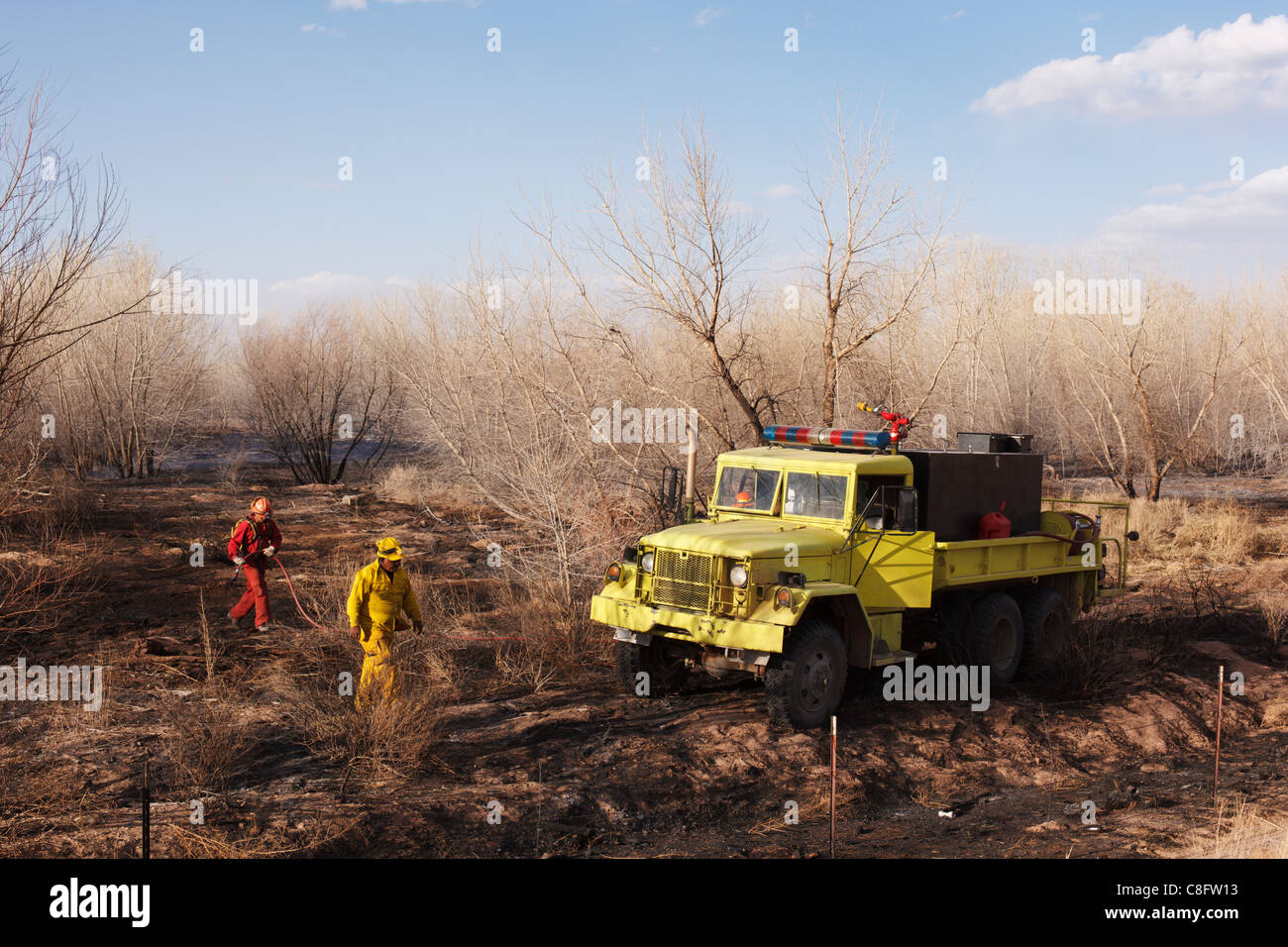 Rural firefighters and truck in New Mexico watering down hot spots from a brush fire. Stock Photo