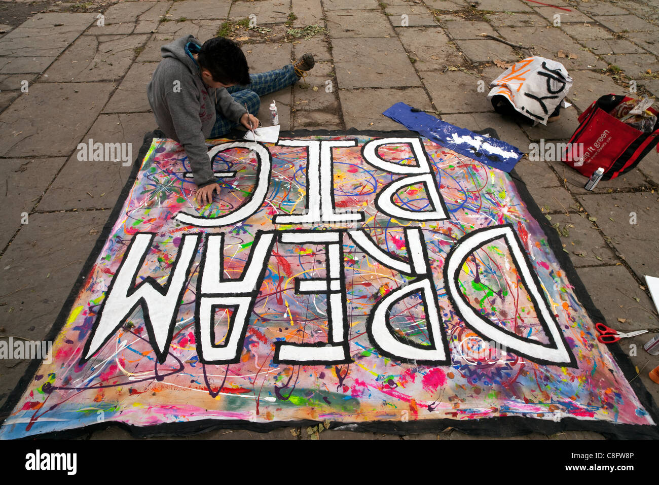 The young man is drawing a sign for 'occupy Toronto' demonstration  in St. James Park  Toronto, Ontario, Canada, on Saturday, Oct. 22, 2011.          'Occupy Toronto' movement that began on October 15, 2011   joined the Occupy Wall Street  and European Indignated movements. Stock Photo