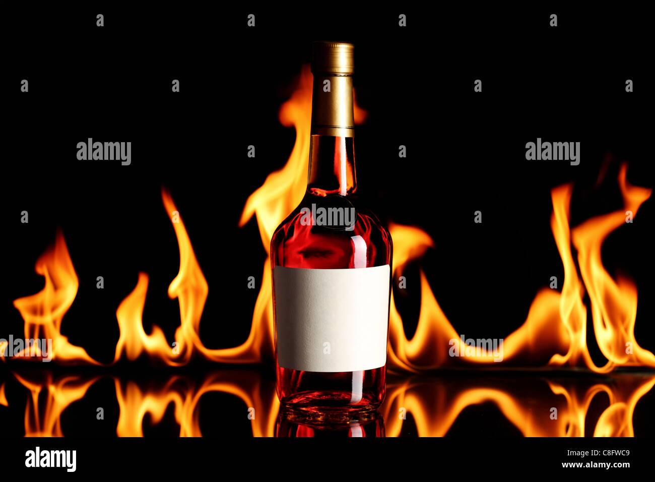 wine brandy bottle with fire flames in the background Stock Photo Alamy