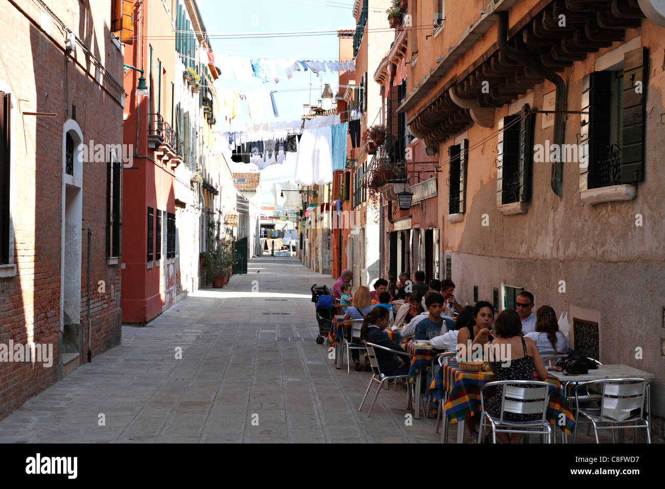 Clothes washing hanging out to dry above street cafe, Venice Italy Stock Photo