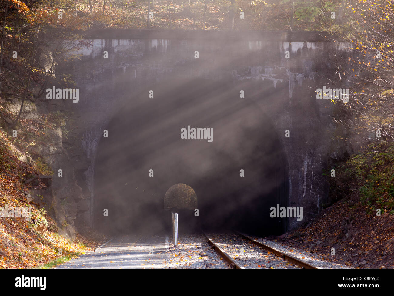 Old steam train leaves smoke and steam after it leaves tunnel Stock Photo