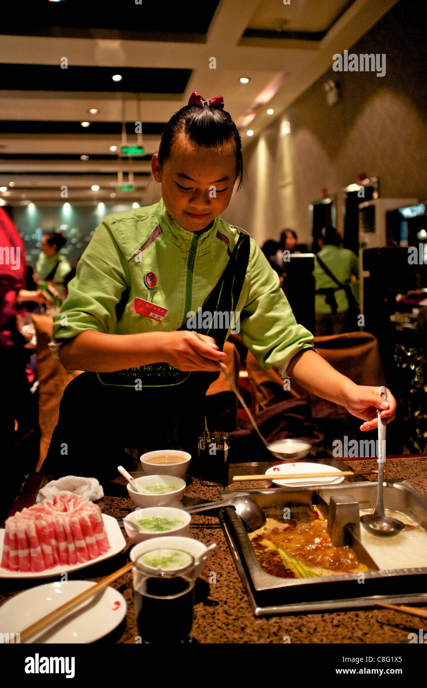 A waitress serves guests at Hai Di Lao hot pot restaurant in Beijing, China. 21-Oct-2011 Stock Photo