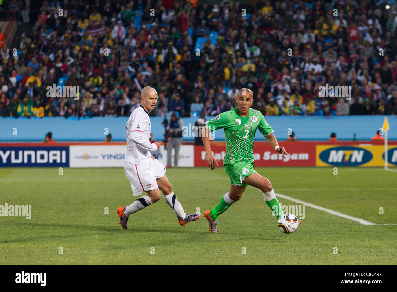 Madjid Bougherra of Algeria (R) looks for space against Michael Bradley of the United States (L) during a 2010 World Cup match. Stock Photo