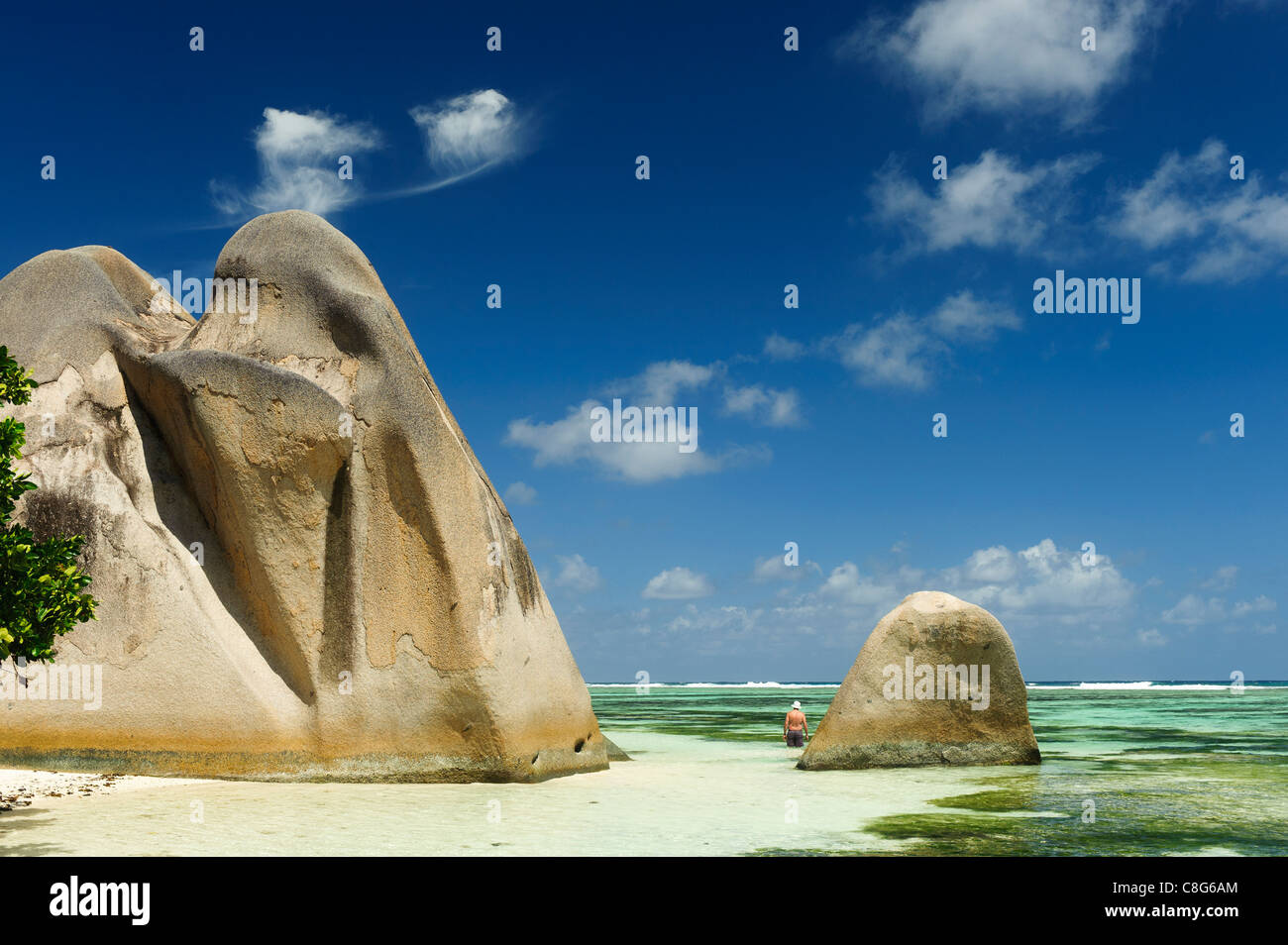 dramatic rock formations that cascade into emerald water of Indian Ocean, Seychelles Stock Photo