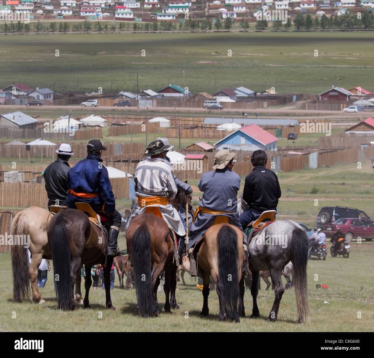 Five locals sit on their horses outside Tsetserleg having watched the horse racing at the local Naadam festival. Stock Photo