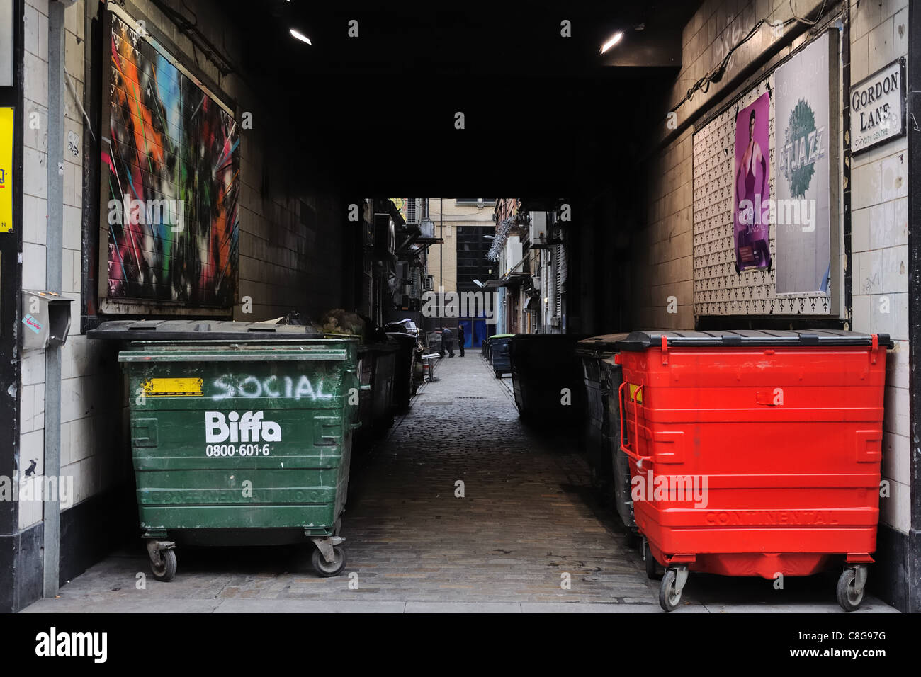 Refuse bins line a back street lane in Glasgow Stock Photo