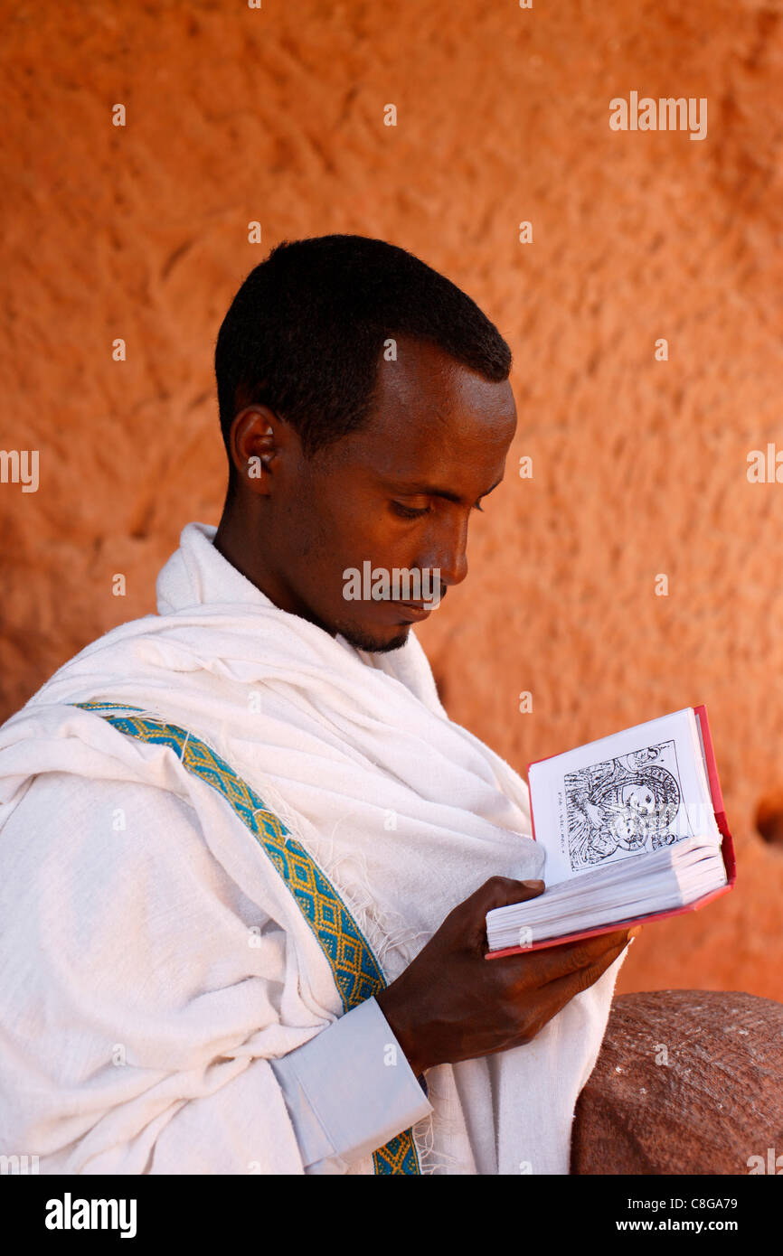 Faithful reading outside a church in Lalibela, Ethiopia Stock Photo