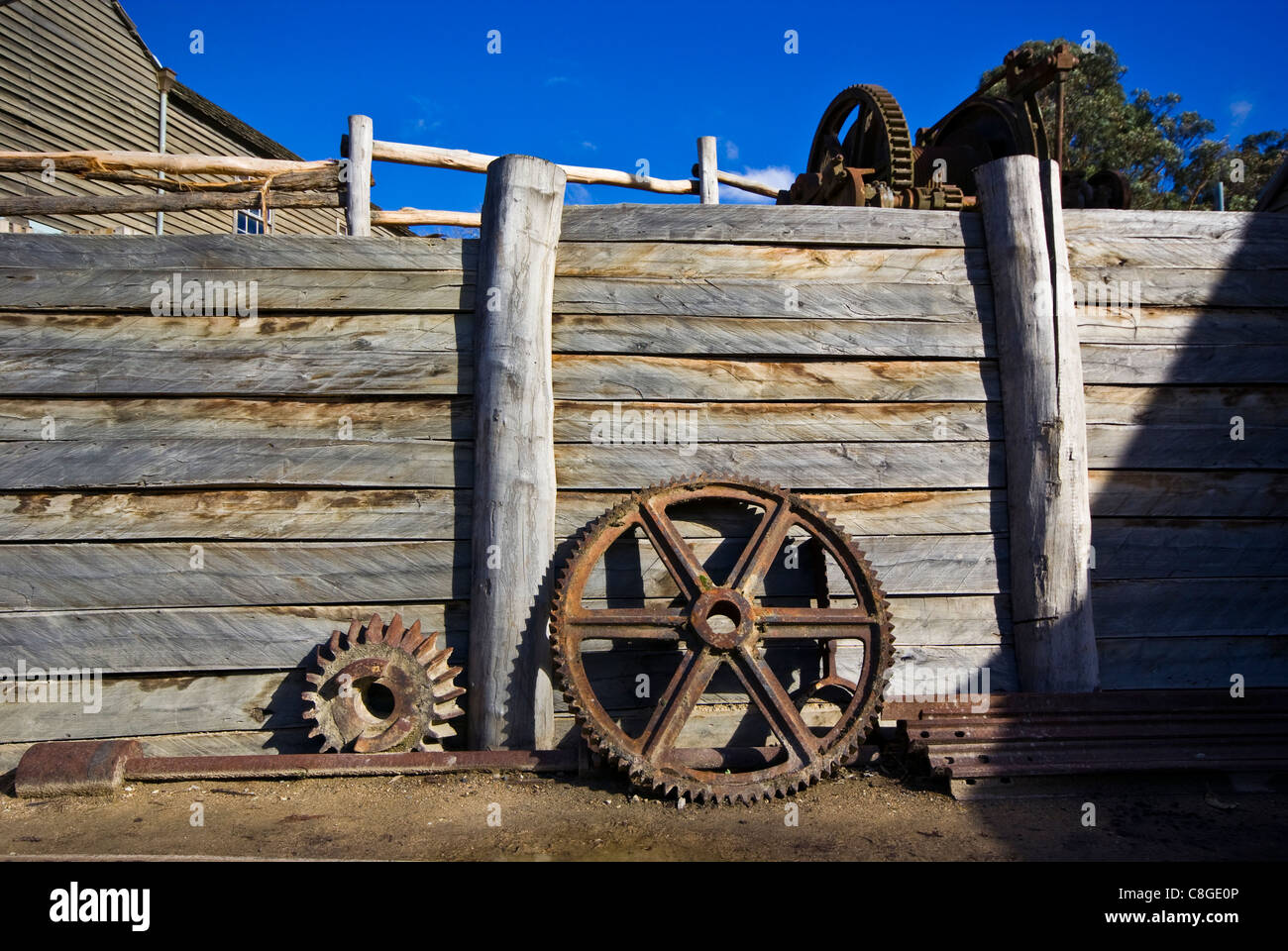 Steam engine steel pulley wheels against a gold mine retaining wall. Stock Photo