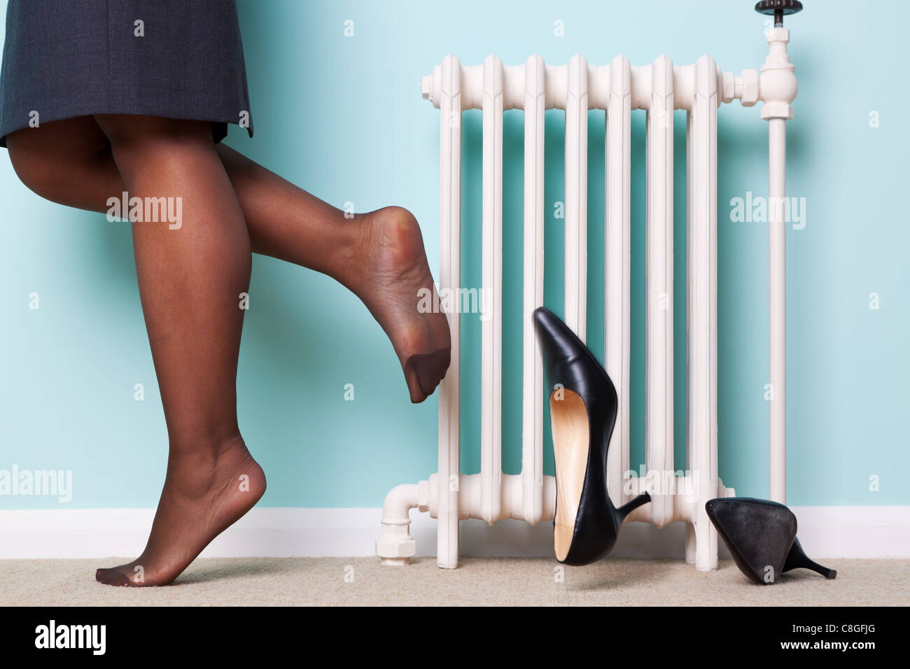 Photo of a businesswomans legs with stockings on kicking her high heel