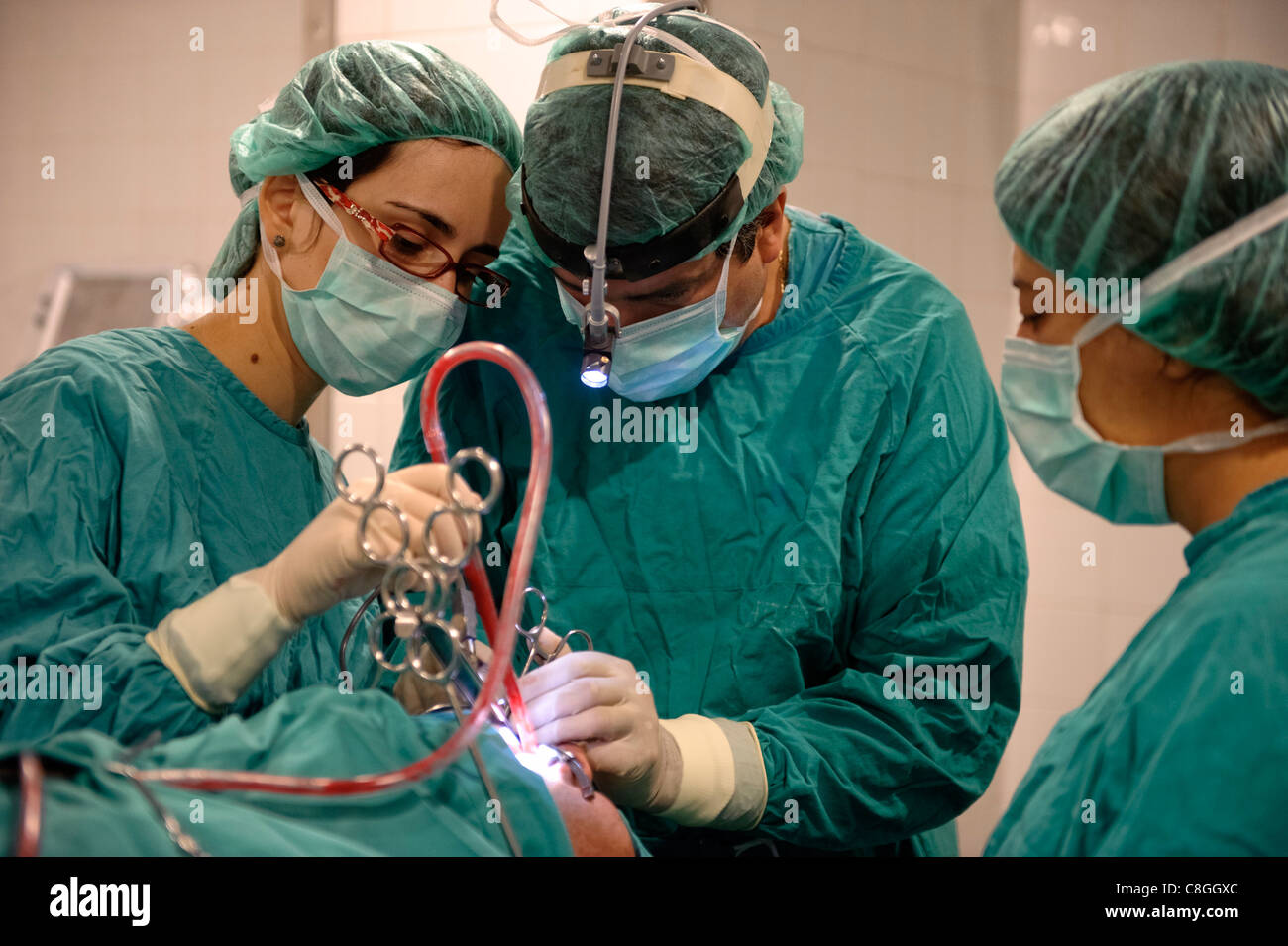 Doctors performing surgery in operating room Stock Photo