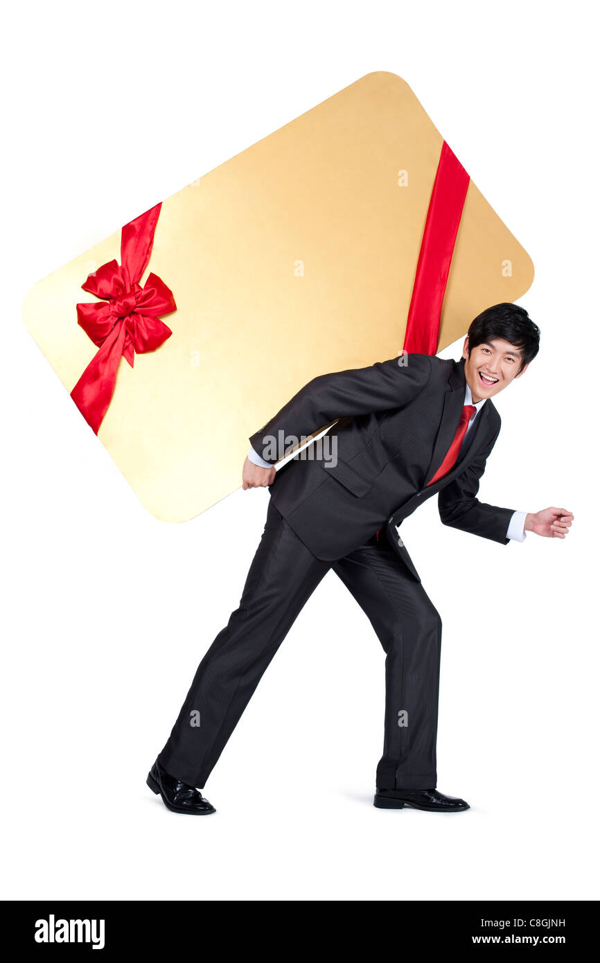 Excited Businessman Holding an Oversized Wrapped Card on His Back Stock Photo