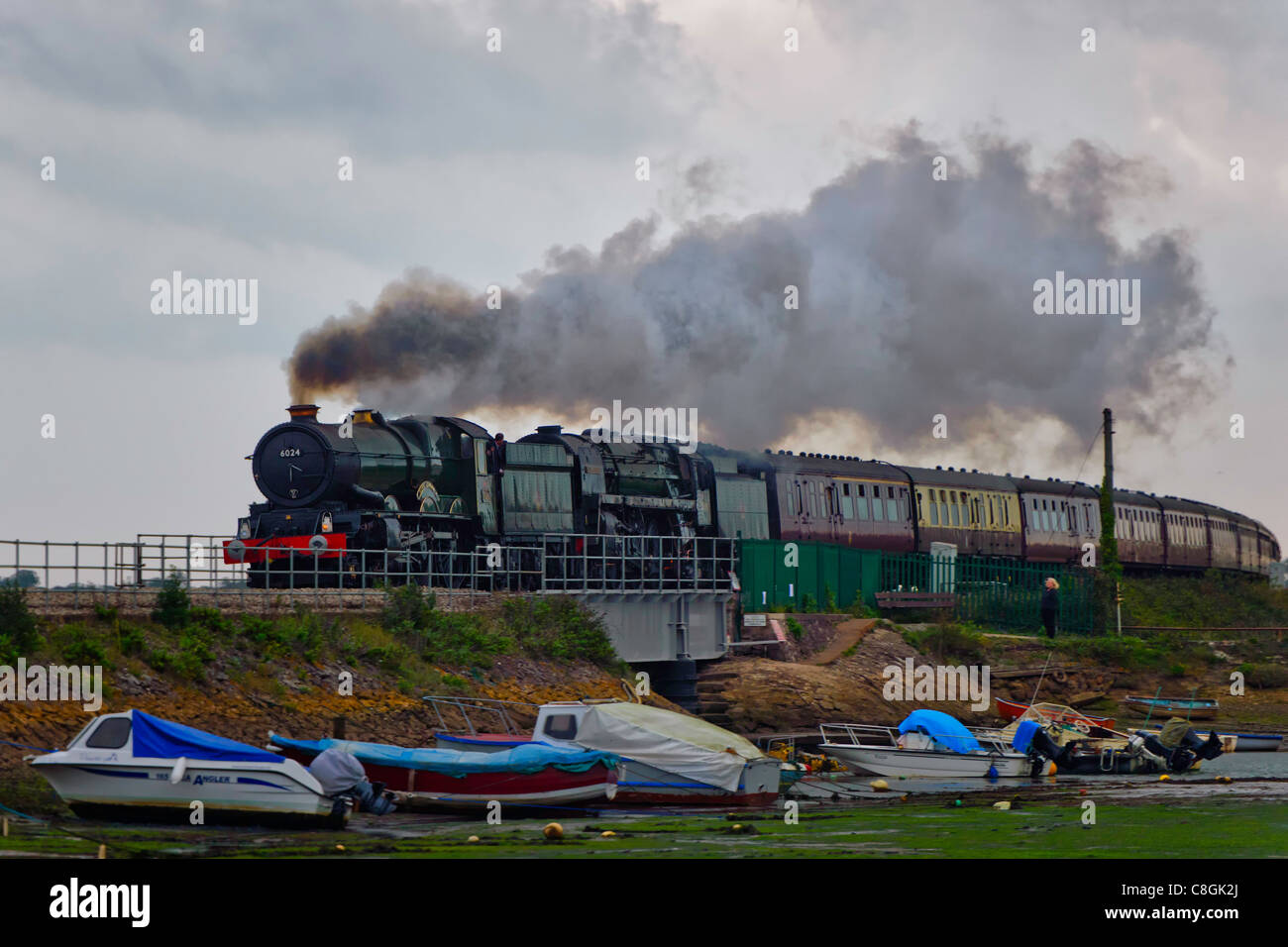 The Devonian double headed by steam locomotives 6024 King Edward I and 70013 Oliver Cromwell passes Cockwood Harbour. Stock Photo