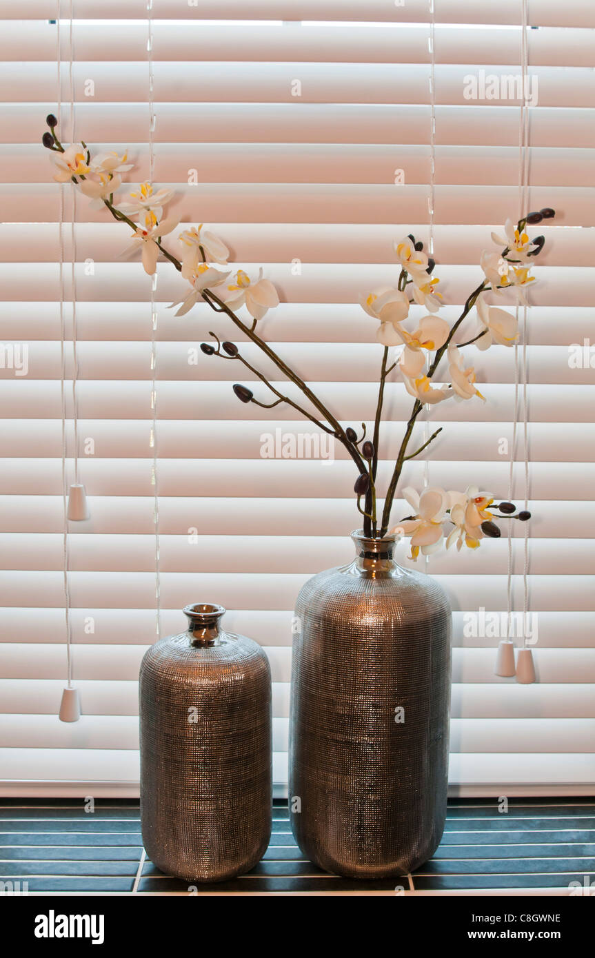 Bottle vases with fake flowers on a window sill Stock Photo Alamy