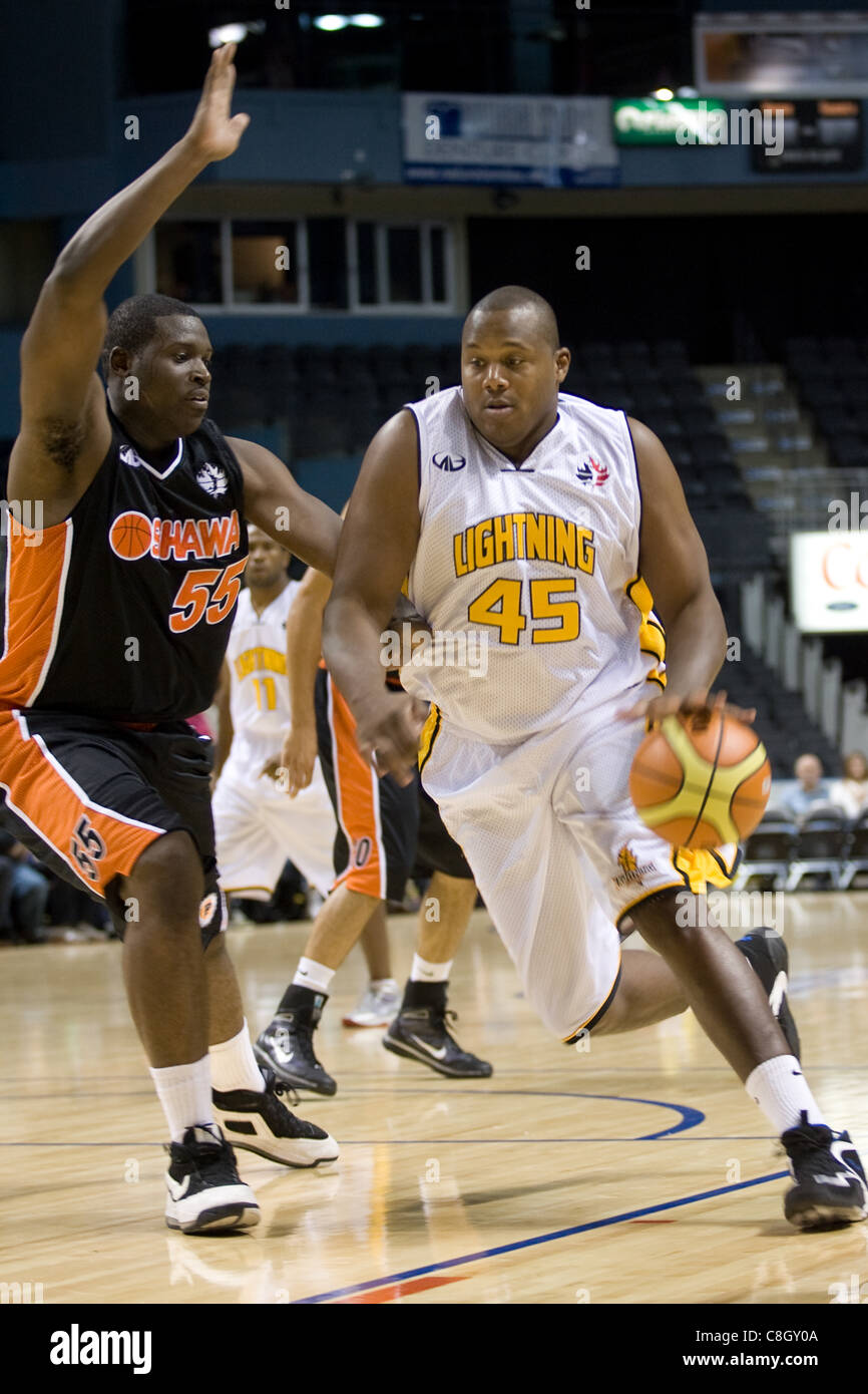 London Ontario, Canada - October 23, 2011. Shawn Daniels (45) drives to the net against Hugh Barnett (55) of the Oshawa Power during their National Basketball League of Canada game. London won the game 111-83. Stock Photo