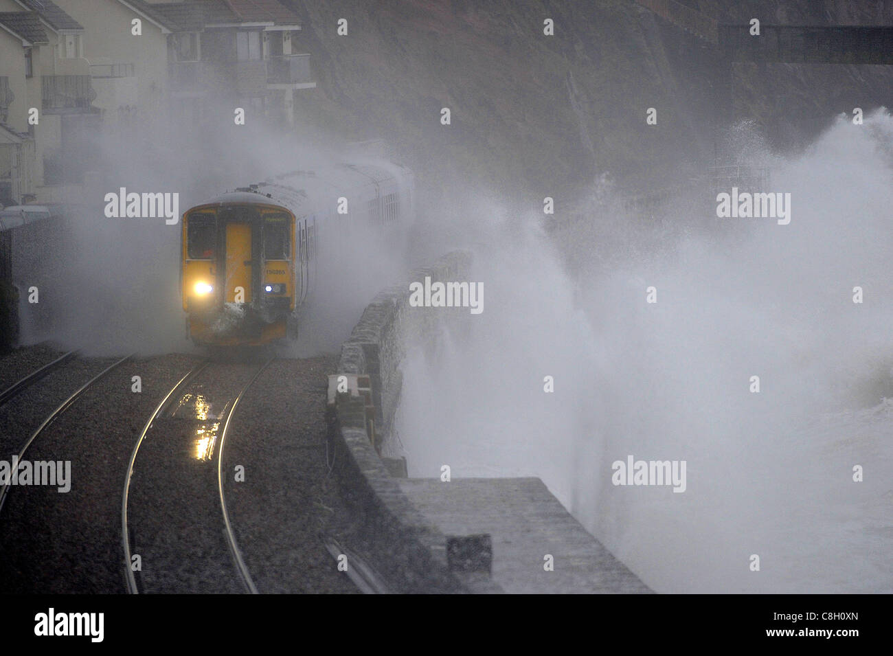 A train is battered by waves at Dawlish in Devon as storms hit the south west of England. Stock Photo