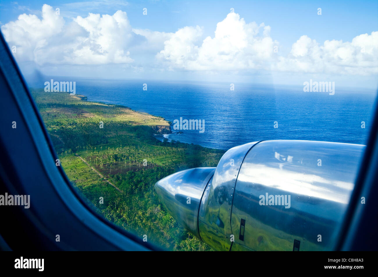 A chrome engine and propellor of a plane flying over tropical islands. Stock Photo