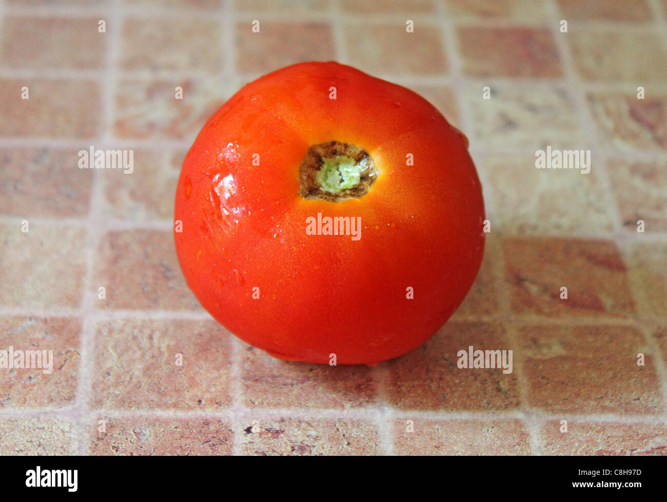 Wet tomato on a table Stock Photo