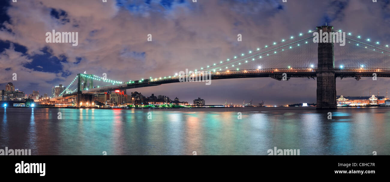 Brooklyn Bridge panorama over East River at night in New York City ...