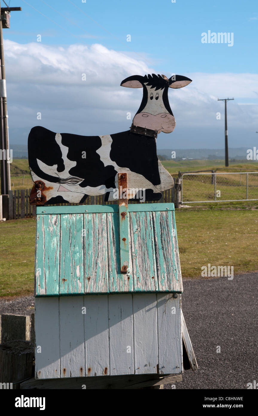 A New Zealand cow announces a farm letter box.   Diese Kuh macht auf den Briefkasten einer Farm in Neuseeland aufmerksam. Stock Photo